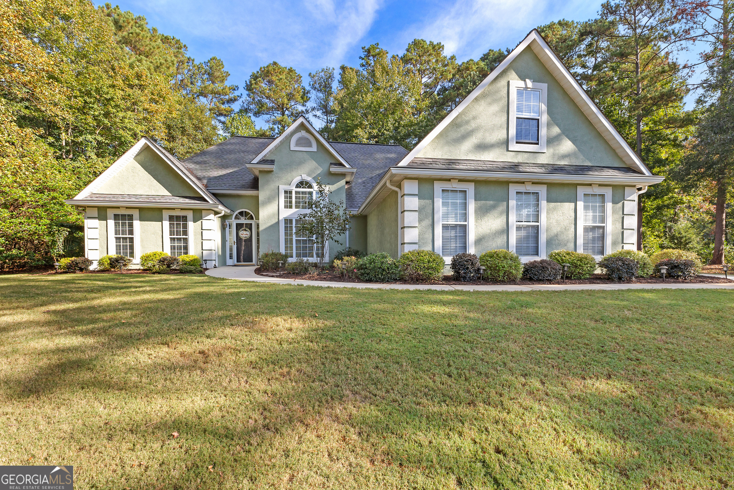 a front view of a house with a garden