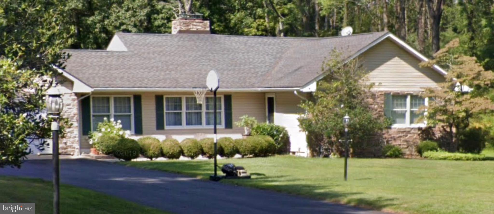 a front view of a house with a yard and potted plants