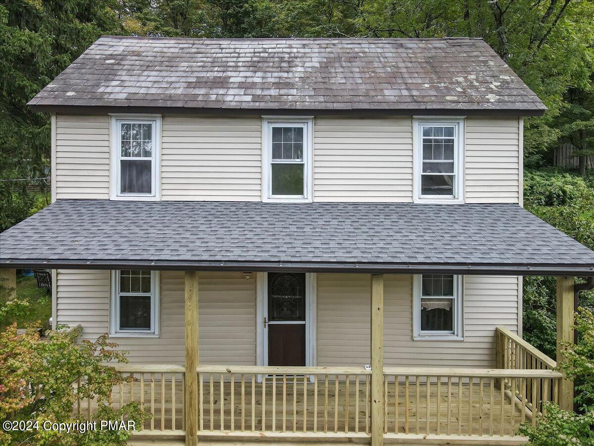 a front view of a house with a wooden roof deck