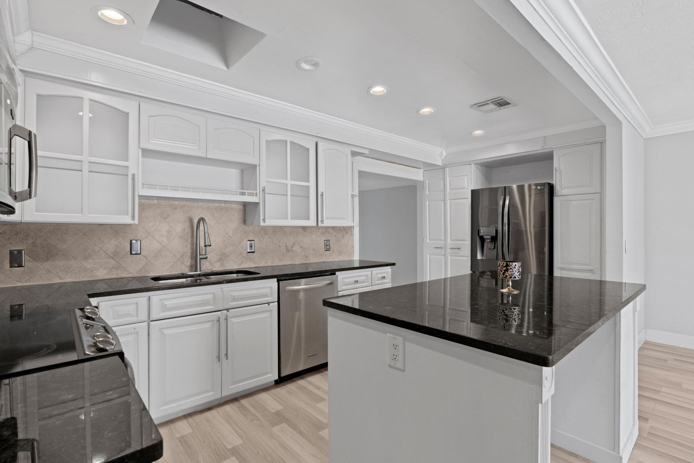 a kitchen with stainless steel appliances granite countertop a sink stove and refrigerator