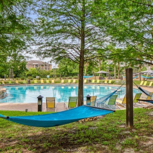 a view of a lake with a yard and large trees