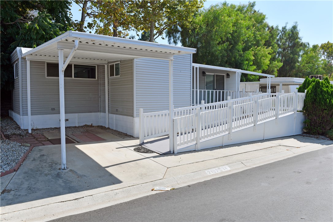 a view of a small house with wooden fence