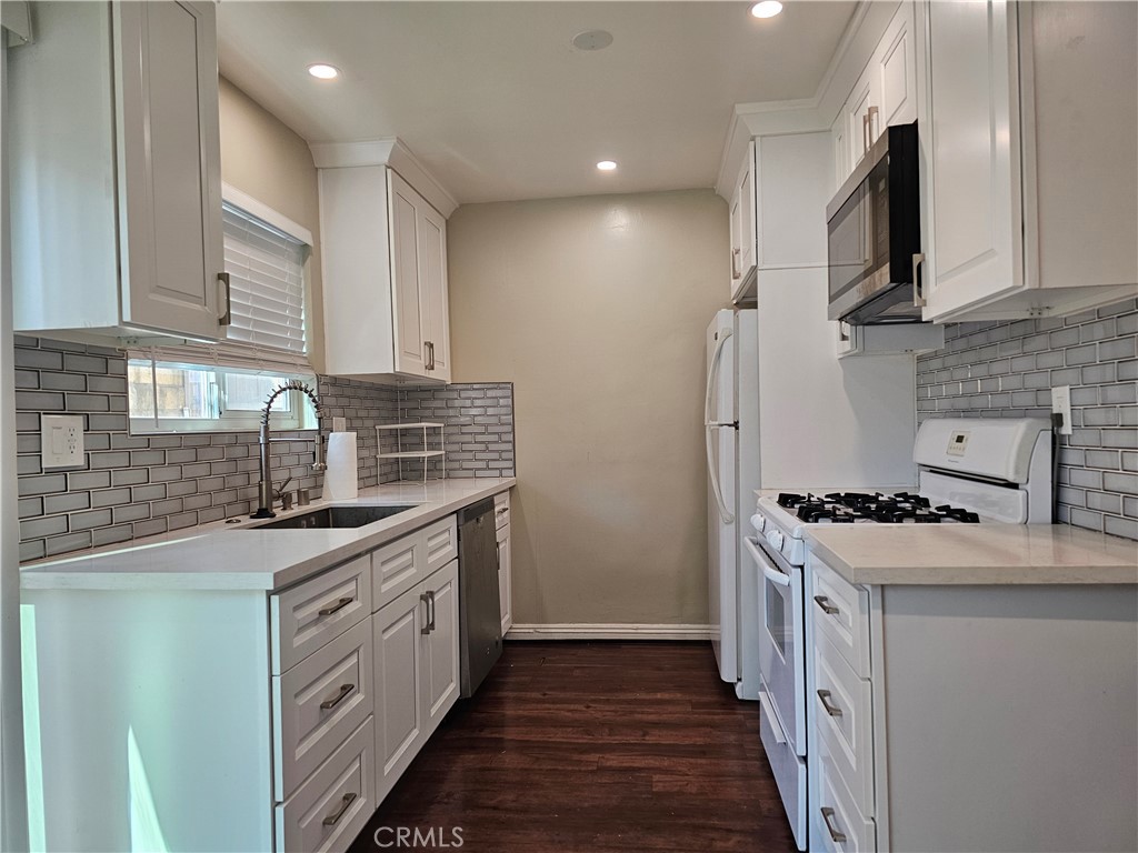 a kitchen with a sink stove top oven and cabinets