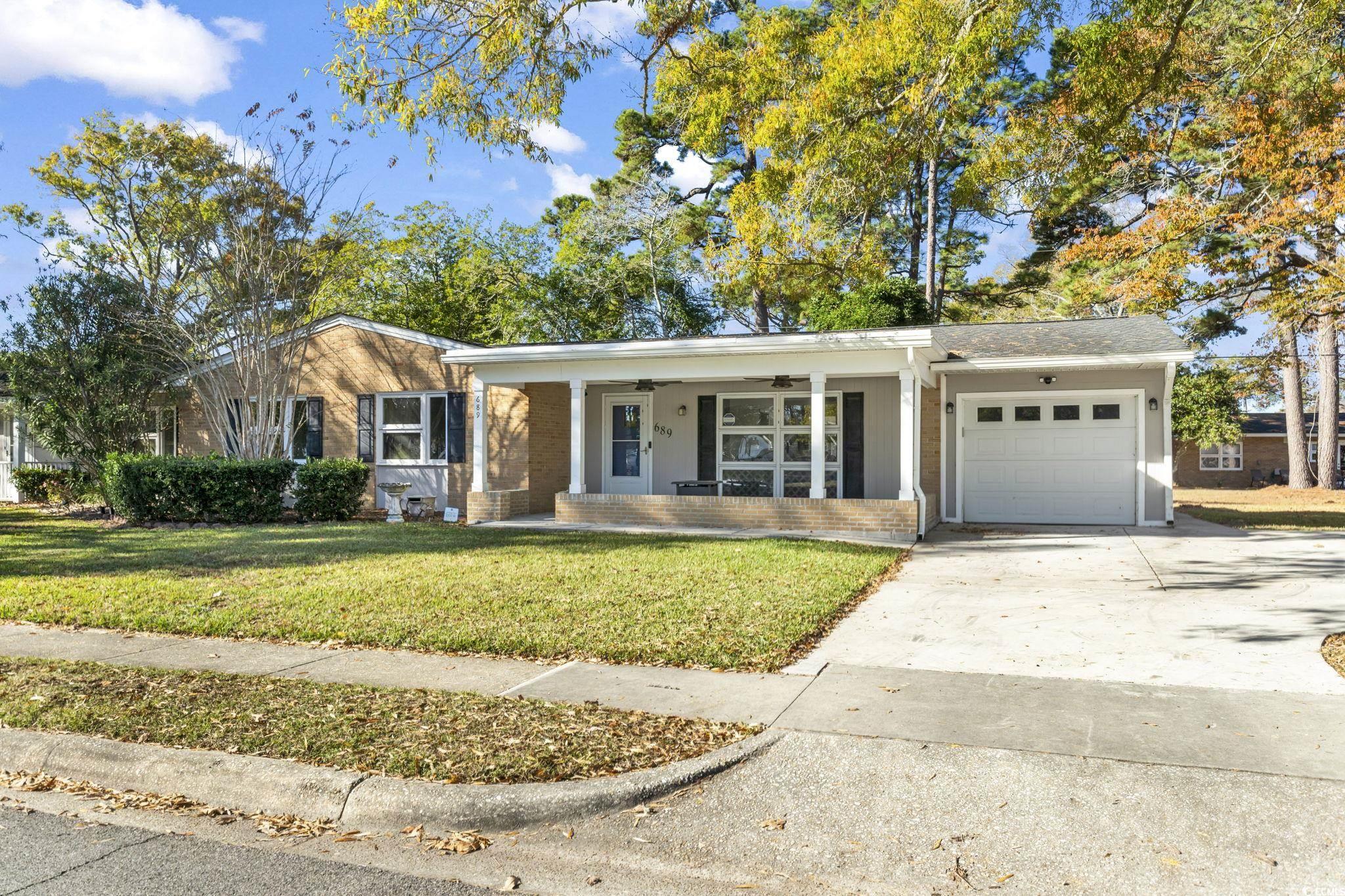 Single story home featuring a porch, a garage, a f