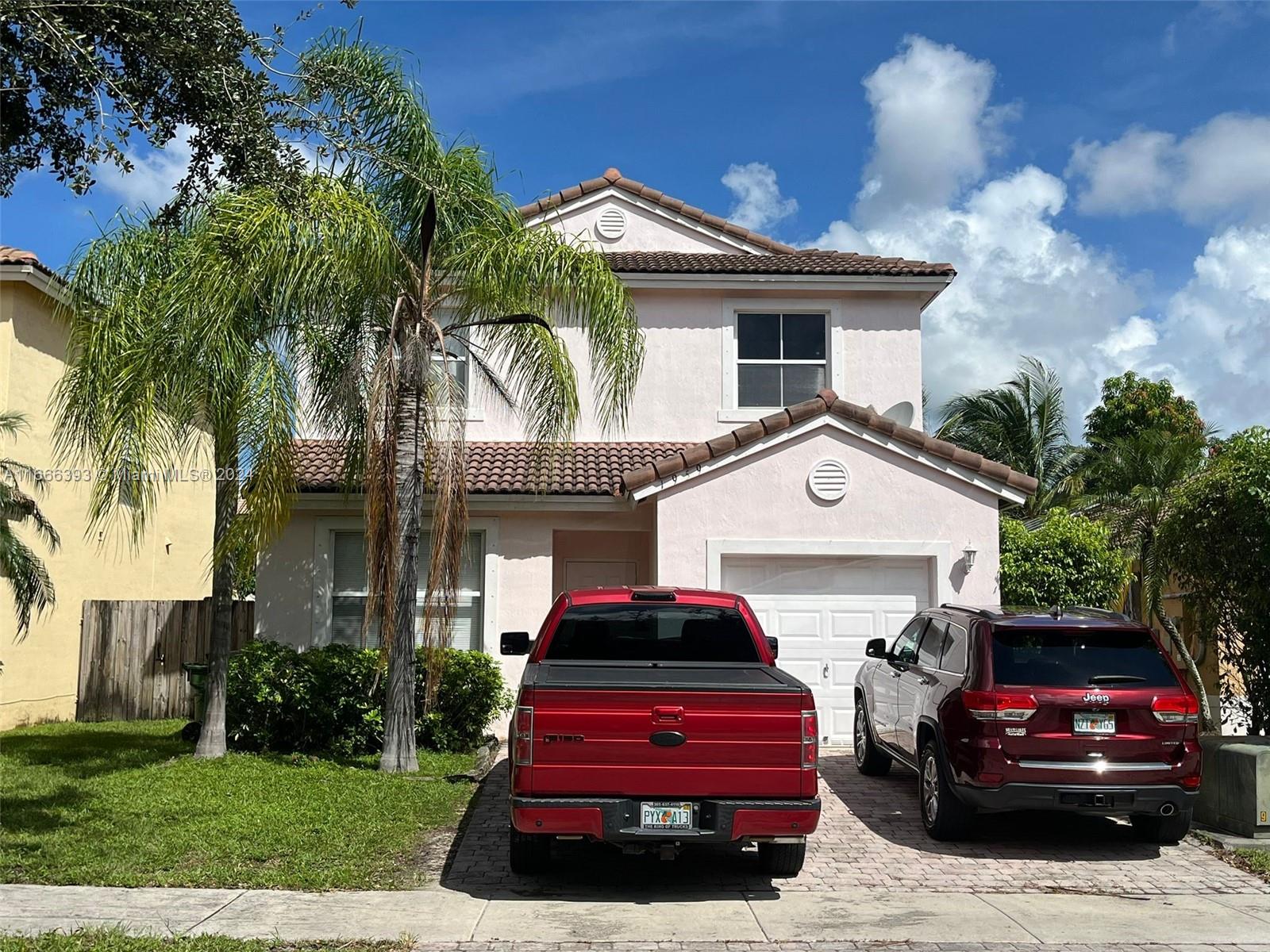 a front view of a house with a garden and parking space