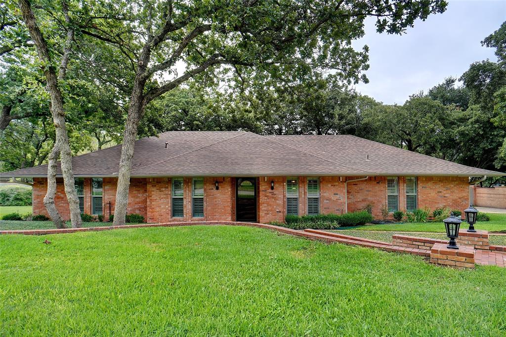 a front view of a house with a yard and green space