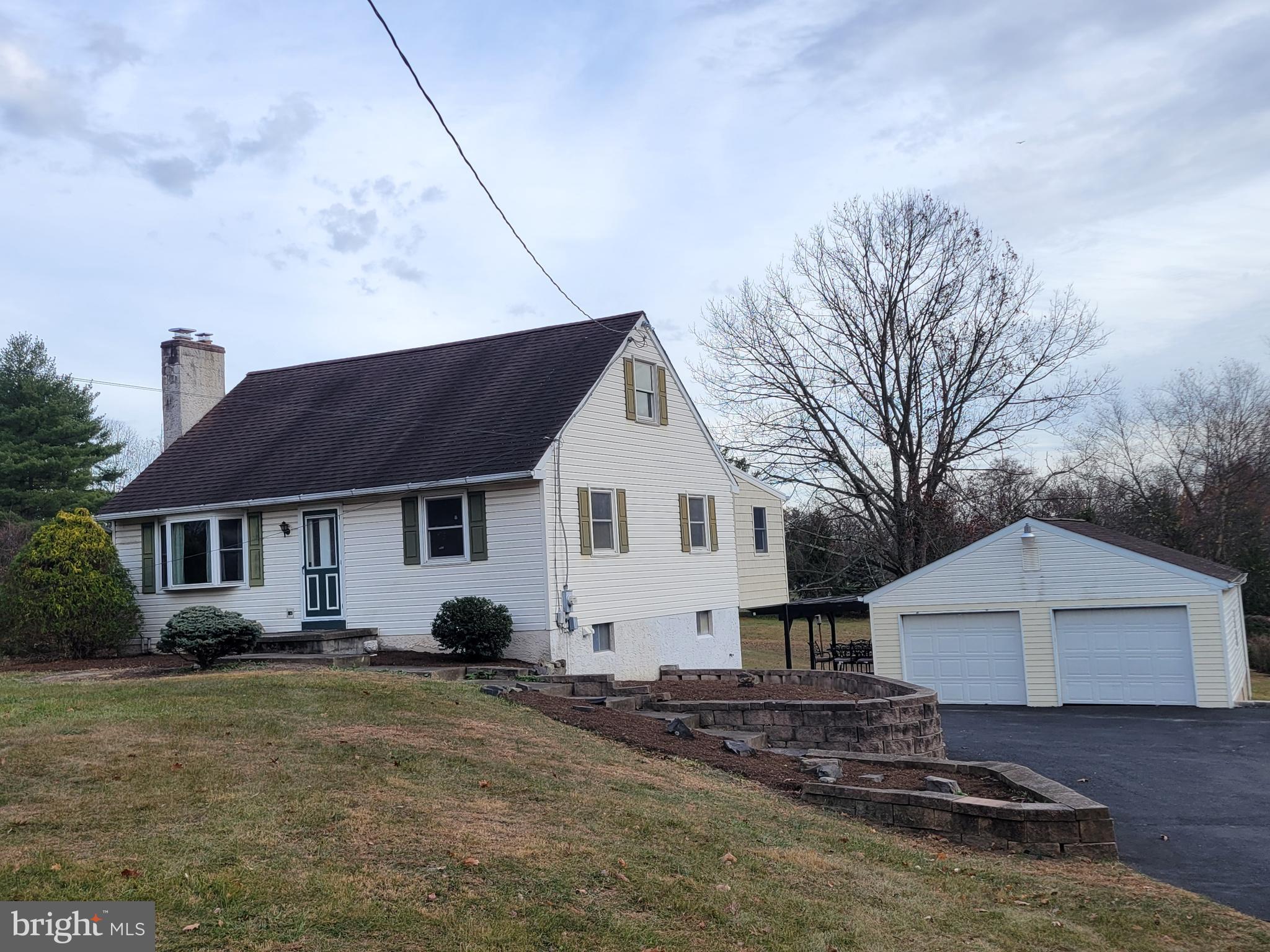 a view of a house with a yard and large tree