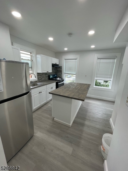 a kitchen with stainless steel appliances granite countertop a refrigerator sink and stove