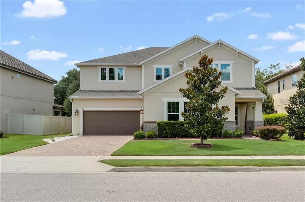 a front view of a house with a yard and trees