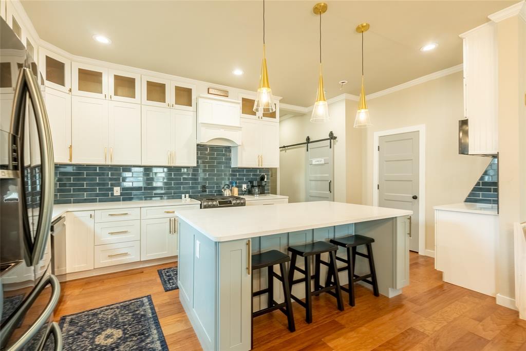 a kitchen with stainless steel appliances granite countertop a sink a stove and a refrigerator