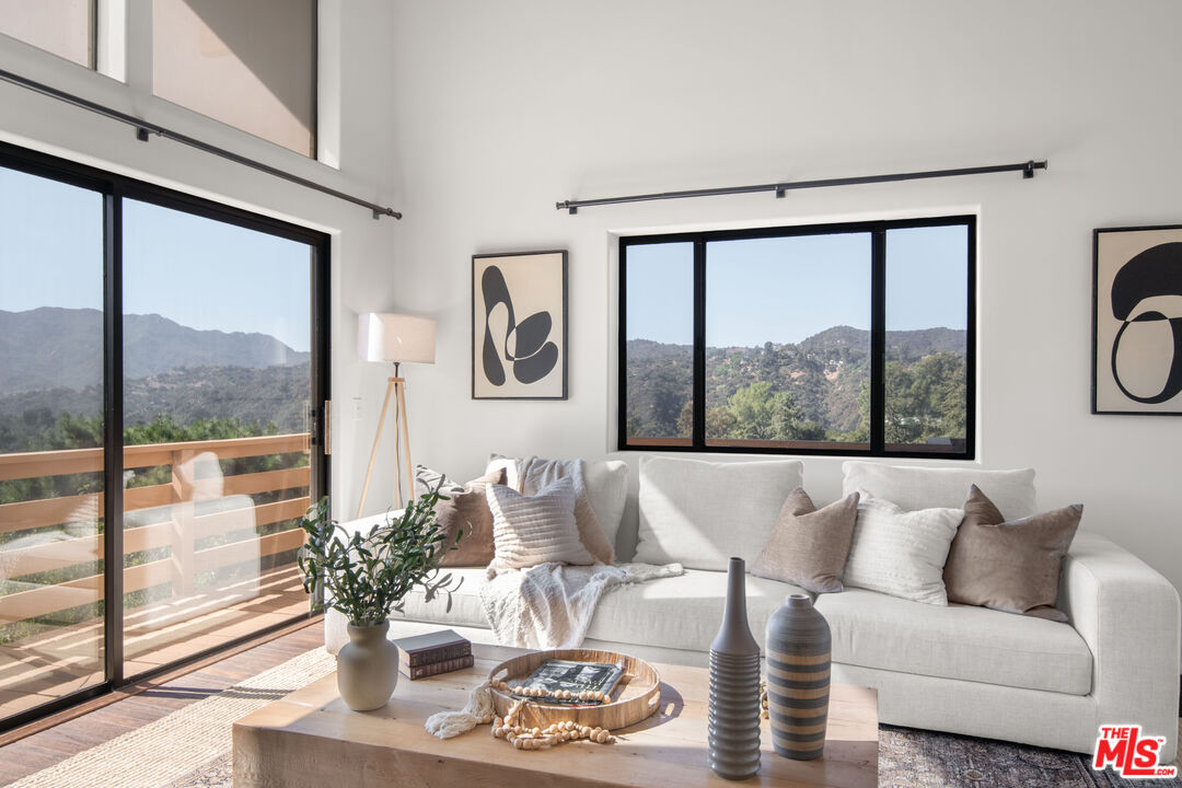 a living room with furniture and a large window with outer view