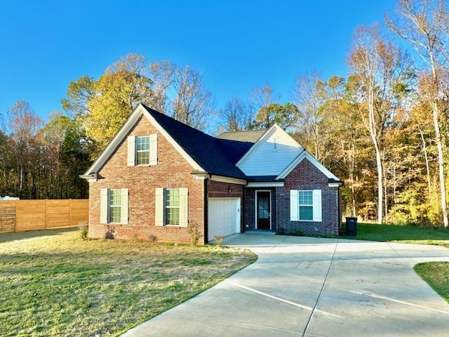 View of front facade featuring a garage and a front yard