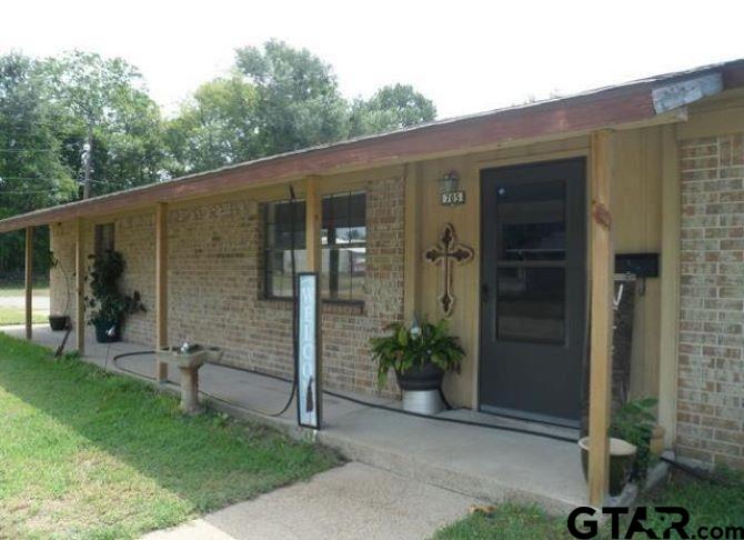 a view of a porch with a potted plant and a yard