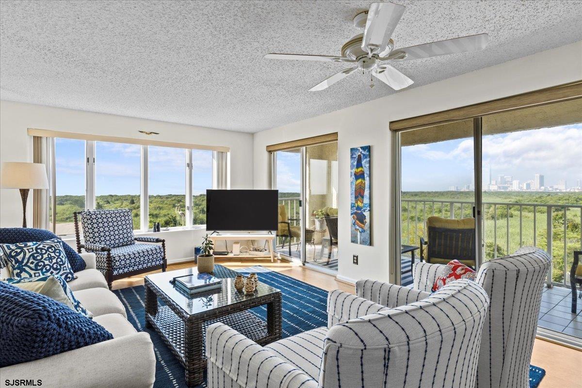 a living room with furniture large windows and a flat screen tv