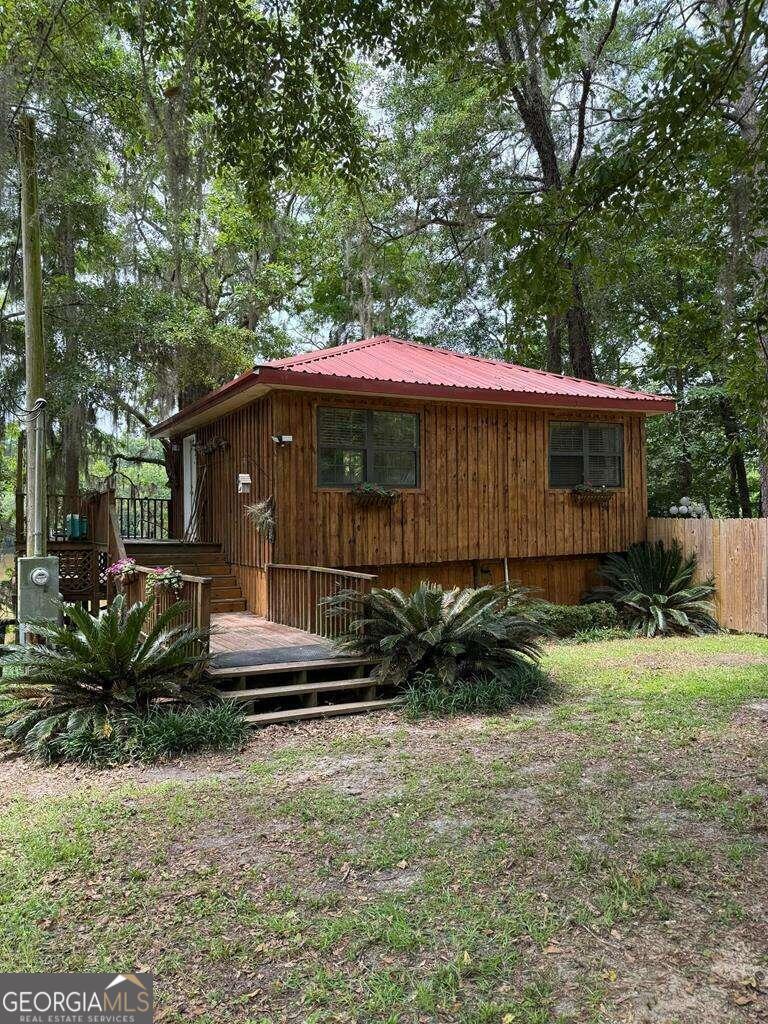 a backyard of a house with plants and tree