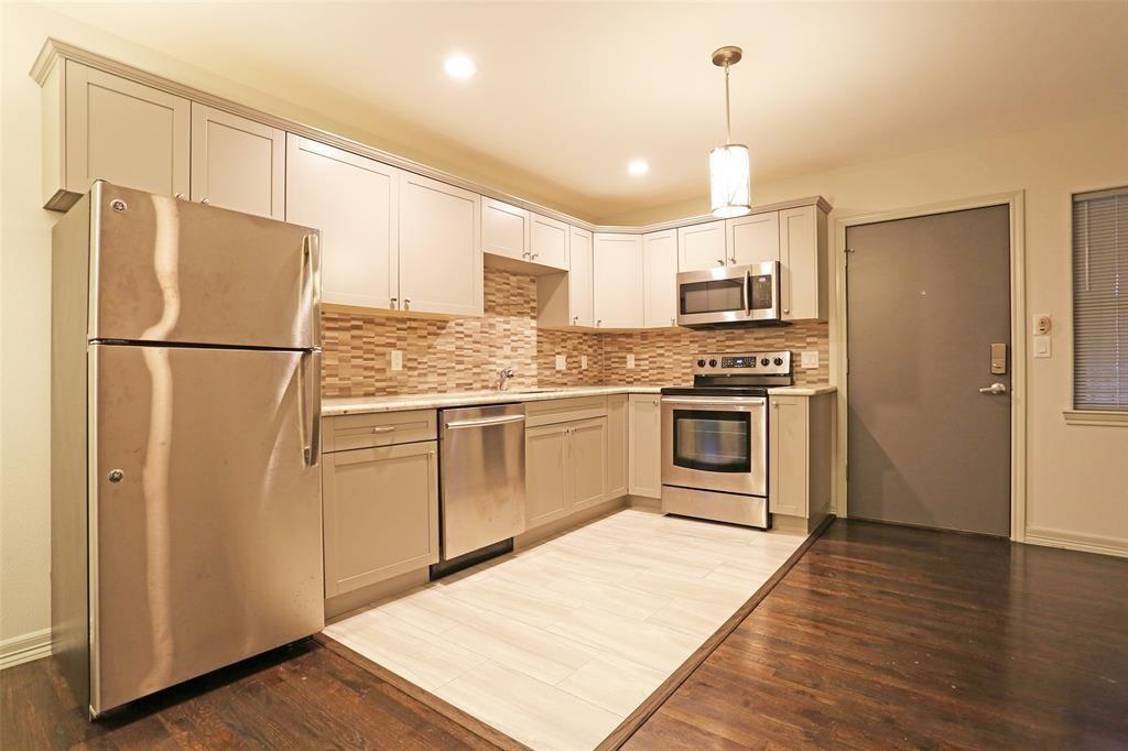 a kitchen with a refrigerator a stove and wooden floor