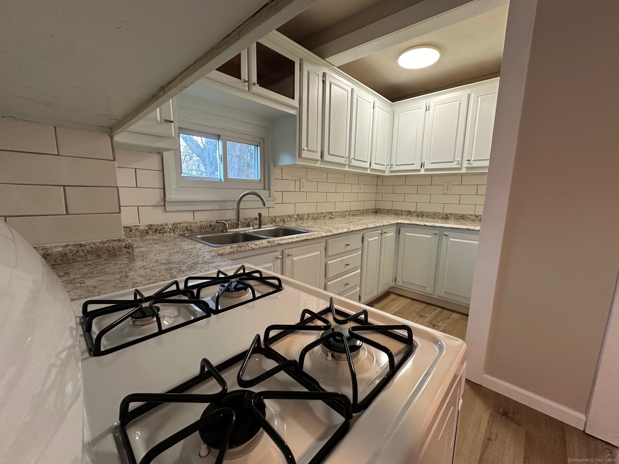 a kitchen with a sink a stove and cabinets