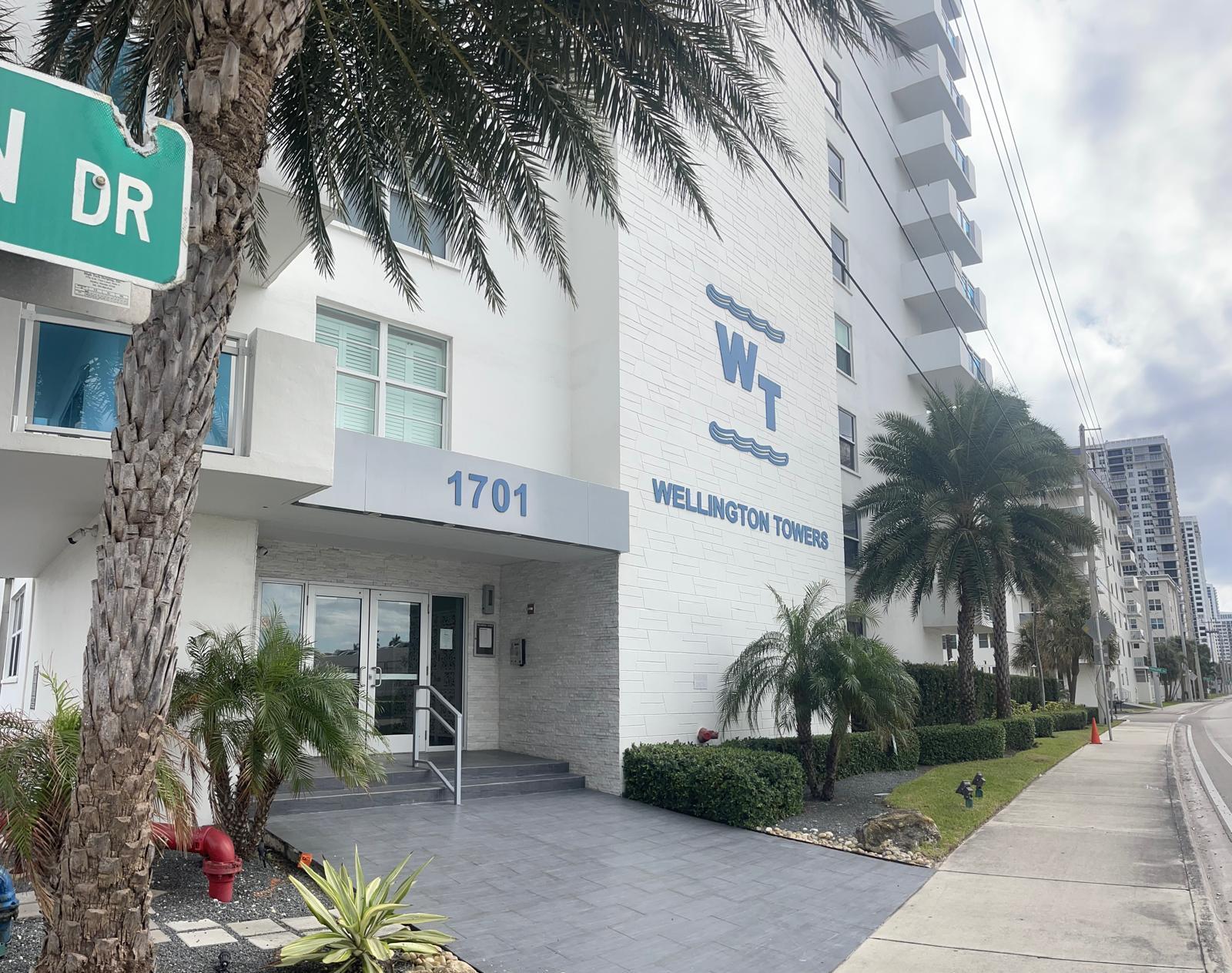 a front view of a building with palm trees