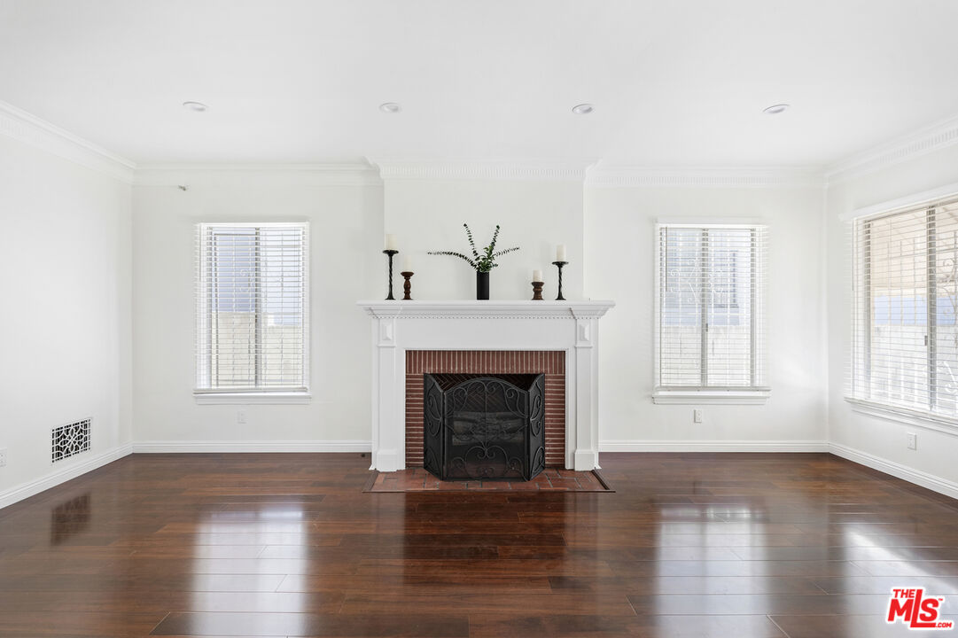 a living room with fireplace and wooden floor