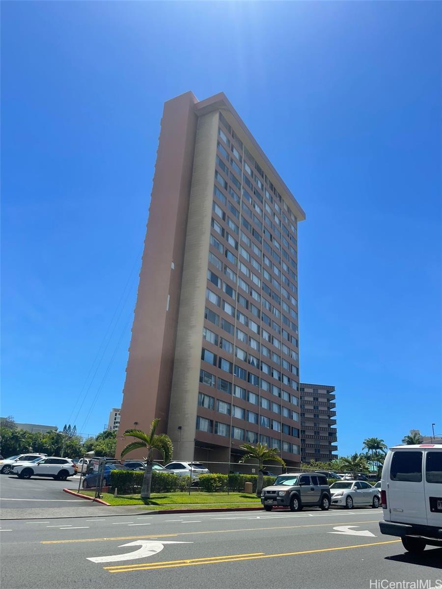 a view of a tall building next to a road