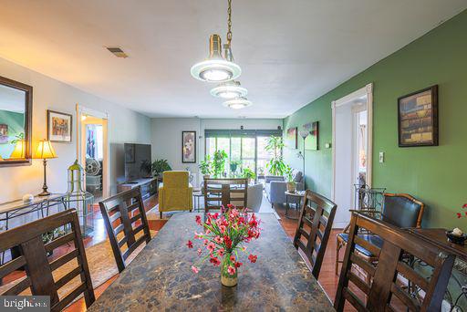 a view of a dining room with furniture a chandelier and windows