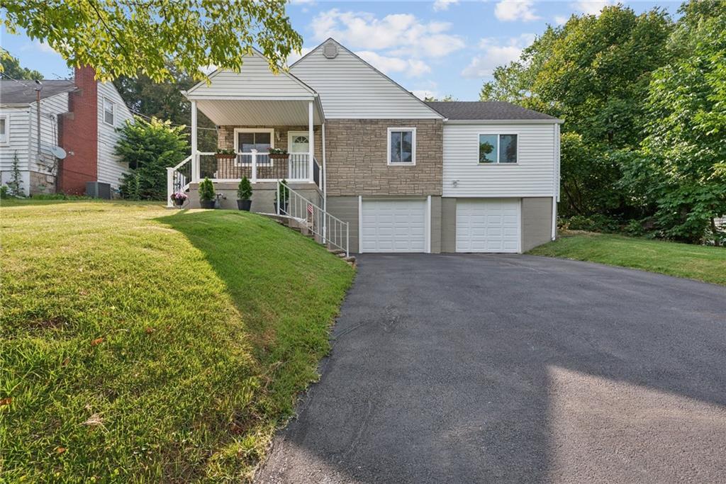 a front view of a house with yard and green space