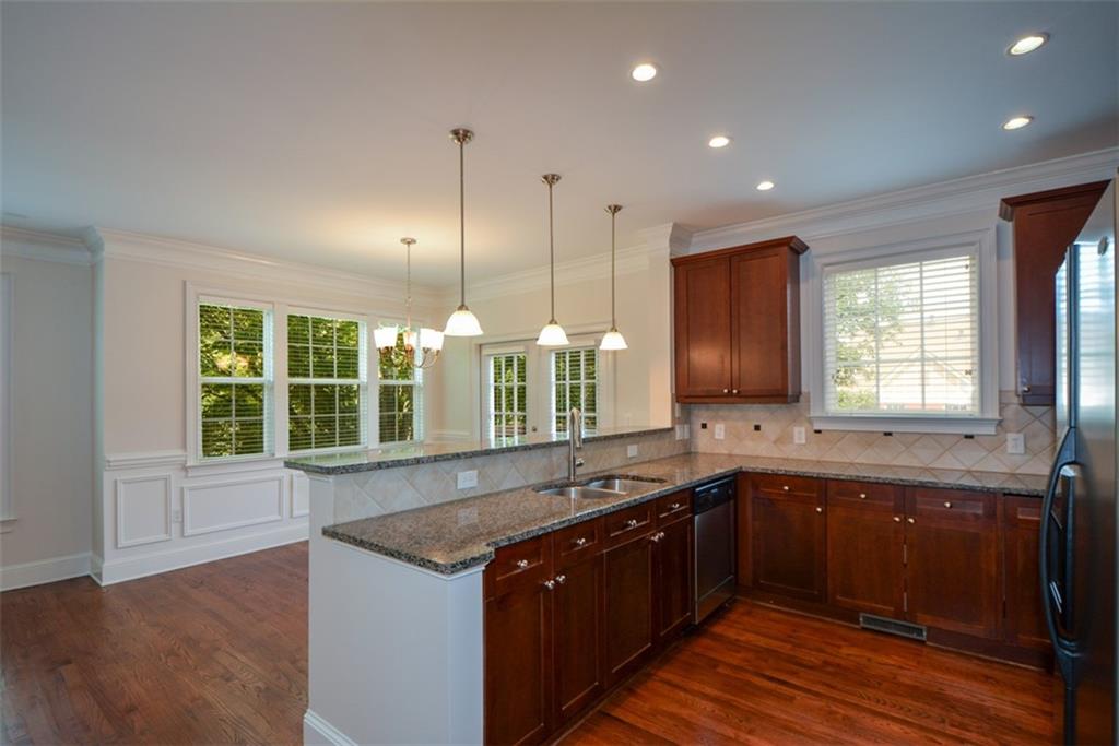 a large kitchen with granite countertop a sink and a stove