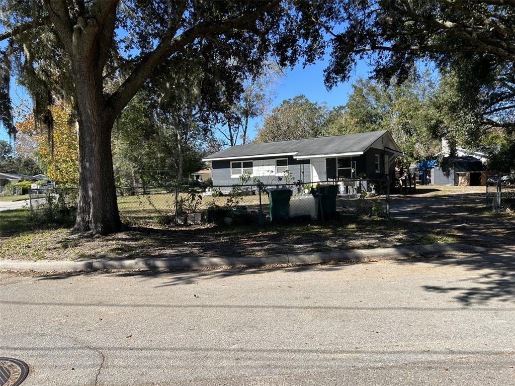 a front view of a house with a yard tree and fence