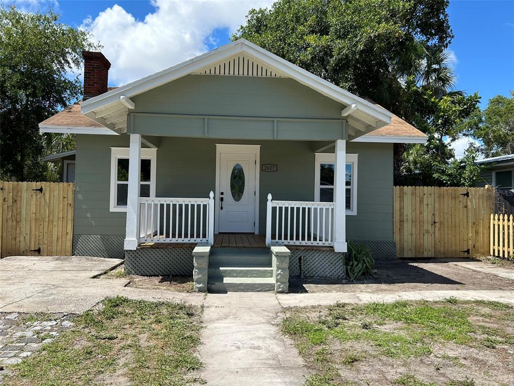 a view of a house with a yard and porch