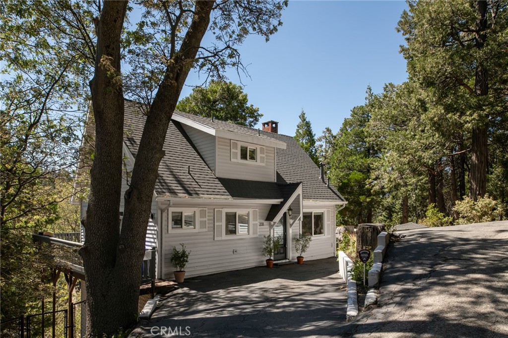 a front view of a house with a tree