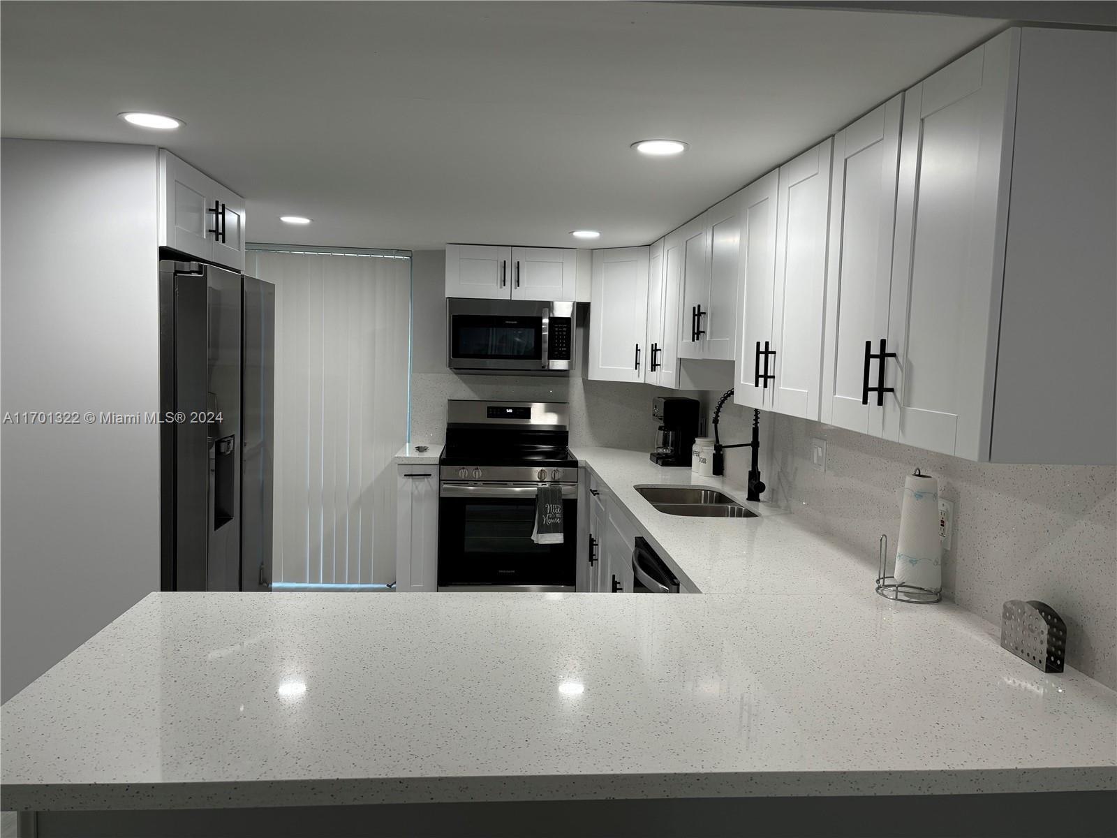 a kitchen with stainless steel appliances a refrigerator sink and stove