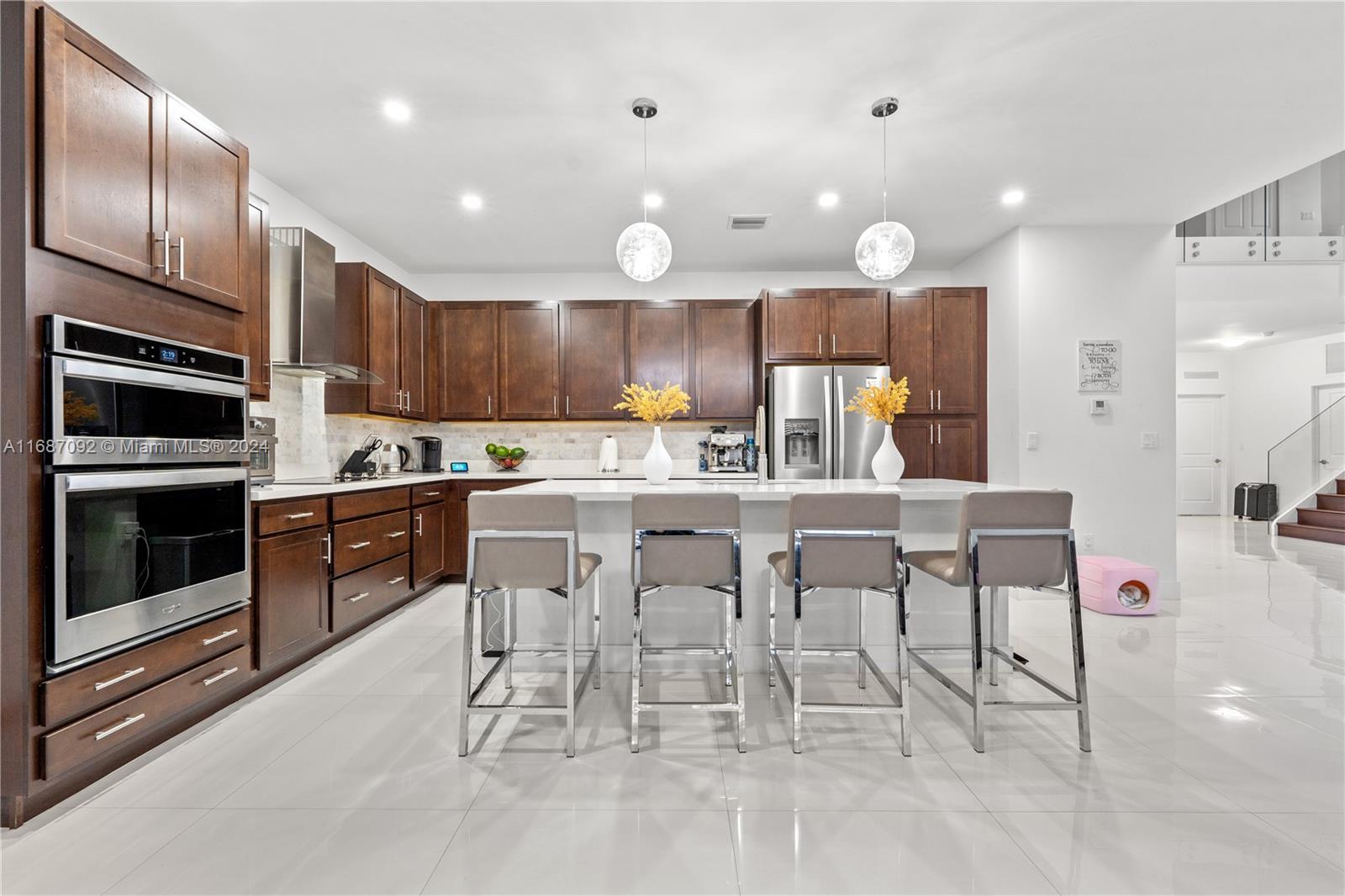 a kitchen with stainless steel appliances kitchen island granite countertop a stove a sink and a refrigerator