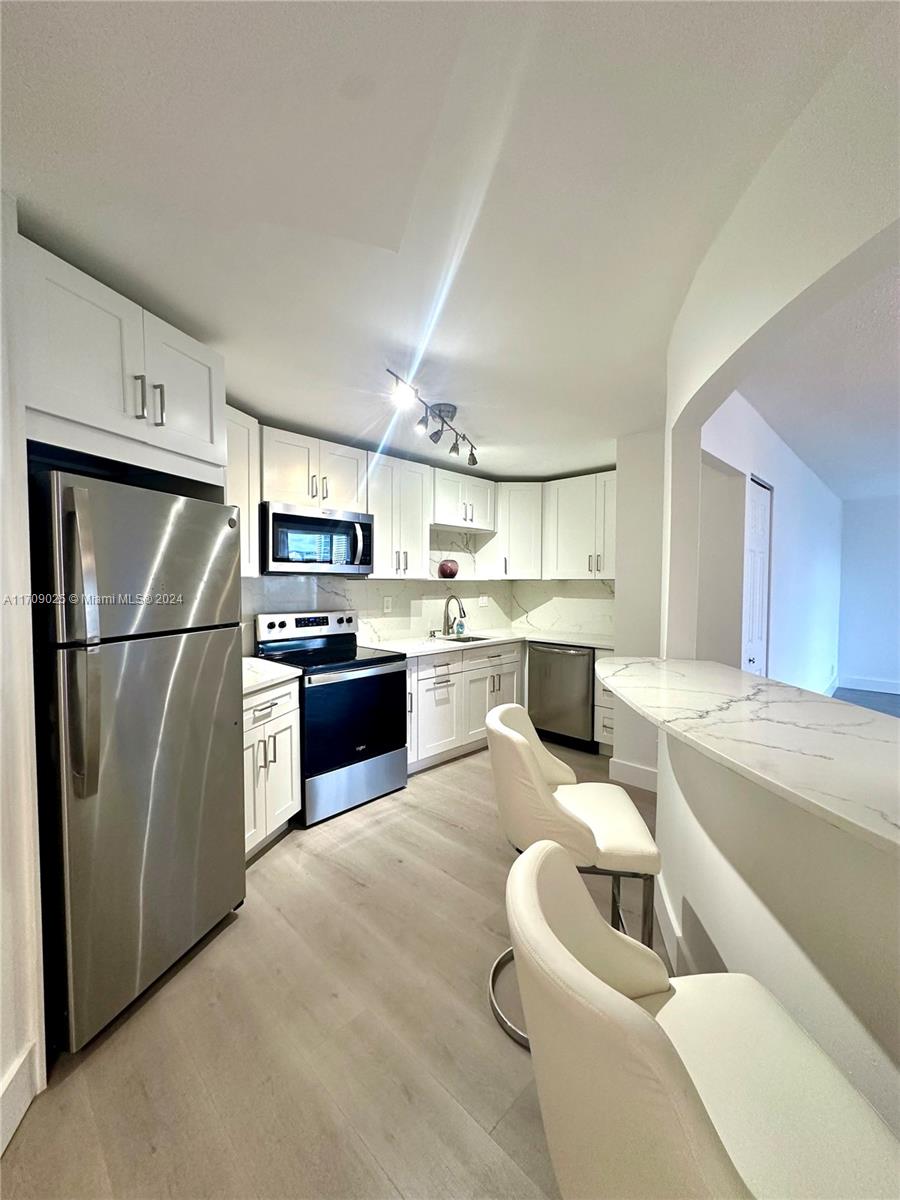 a kitchen with stainless steel appliances granite countertop a refrigerator sink and cabinets