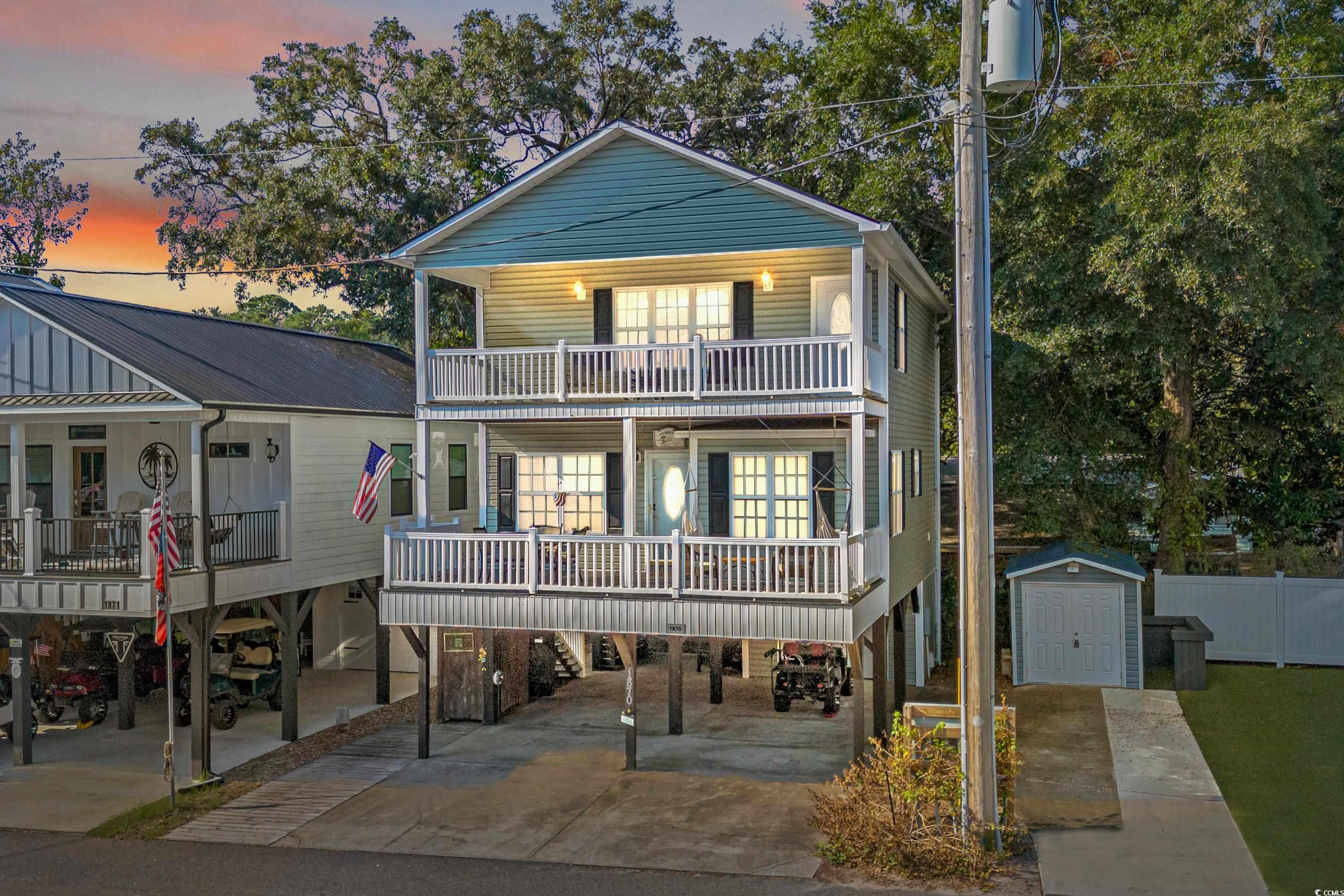 Coastal home with a storage unit, a carport, cover