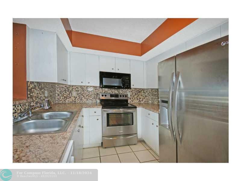 a kitchen with a sink stainless steel appliances and a counter top space