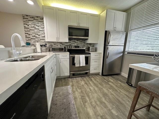 a kitchen with a sink cabinets and stainless steel appliances