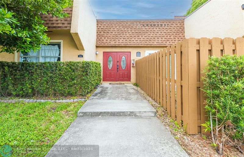 a view of a pathway house with wooden fence