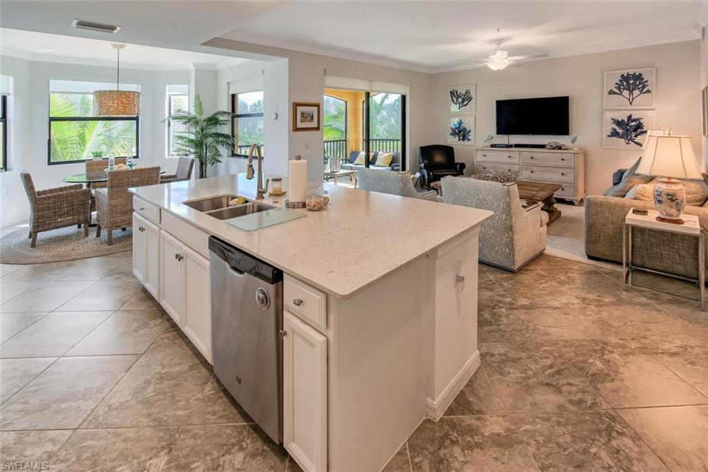 a large white kitchen with a large window and furniture