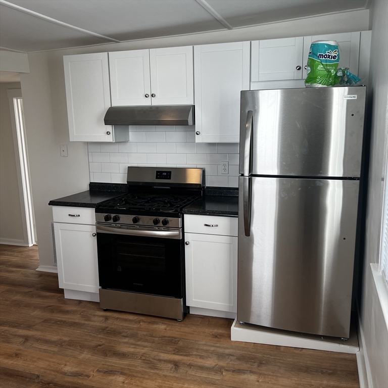 a kitchen with a refrigerator and a stove