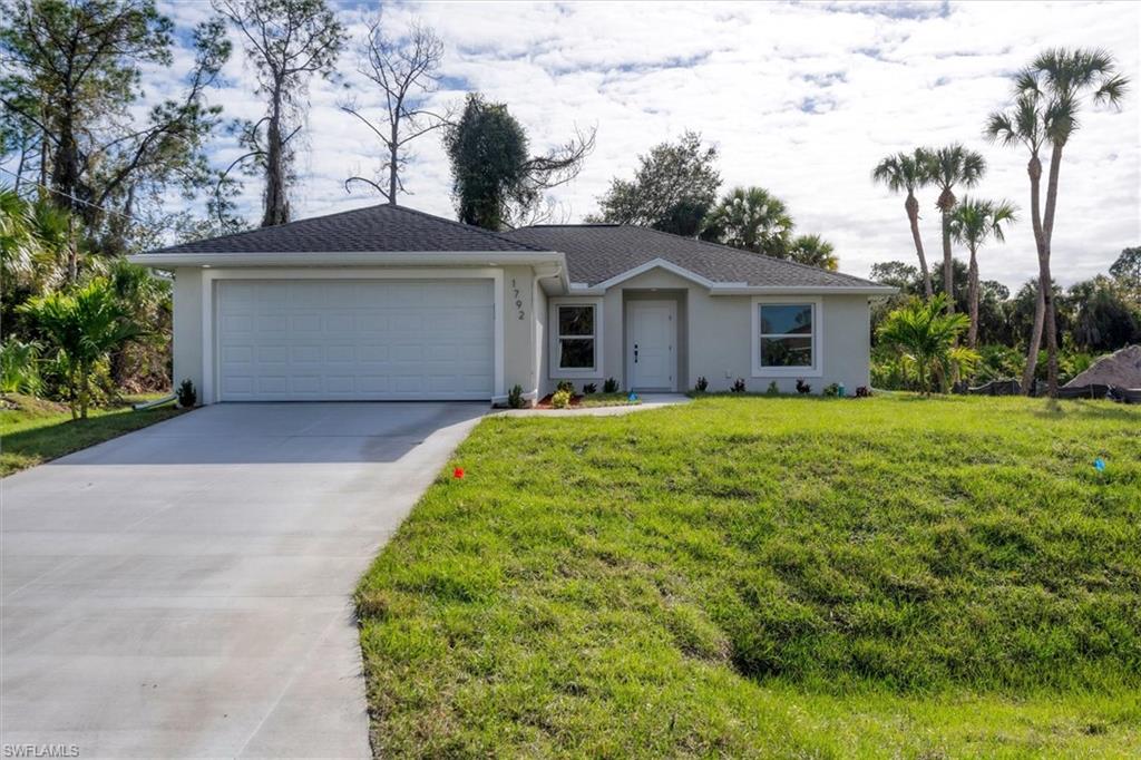 Ranch-style home with a front yard and a garage