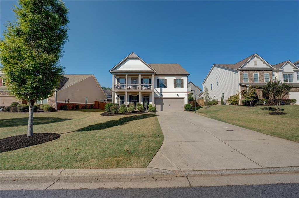 a front view of a house with yard and parking