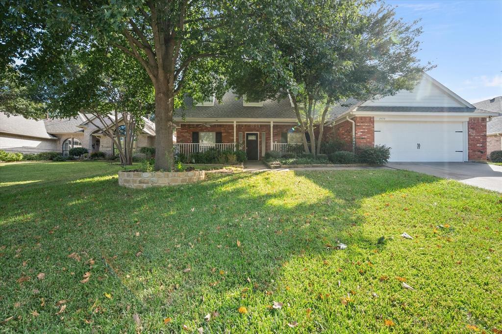 a front view of a house with a yard and trees