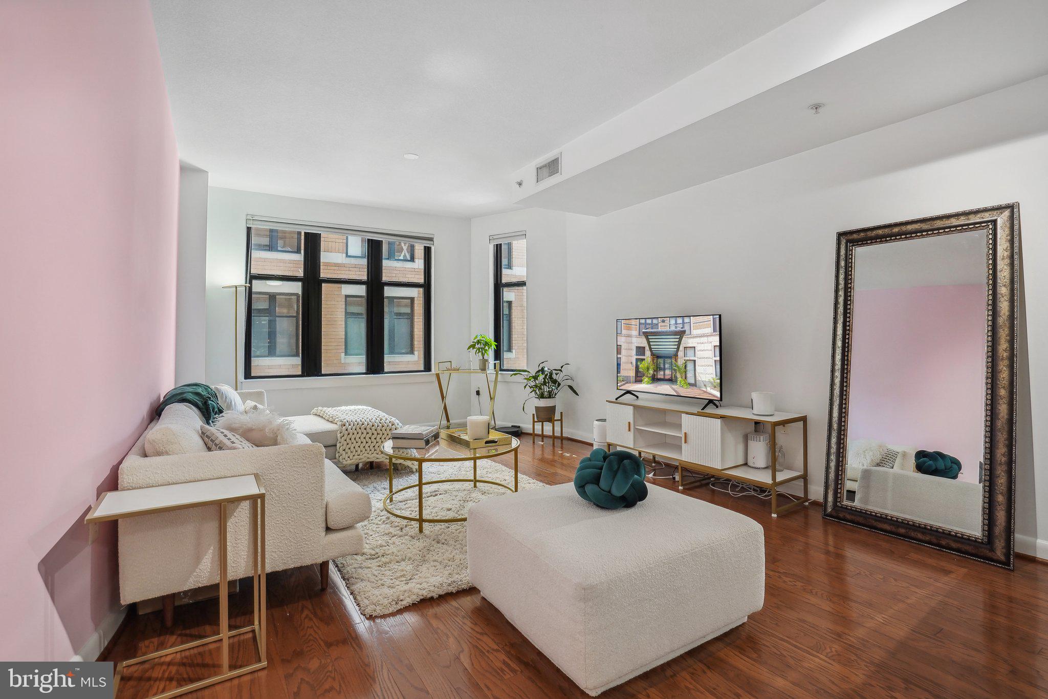 a living room with furniture and a wooden floor