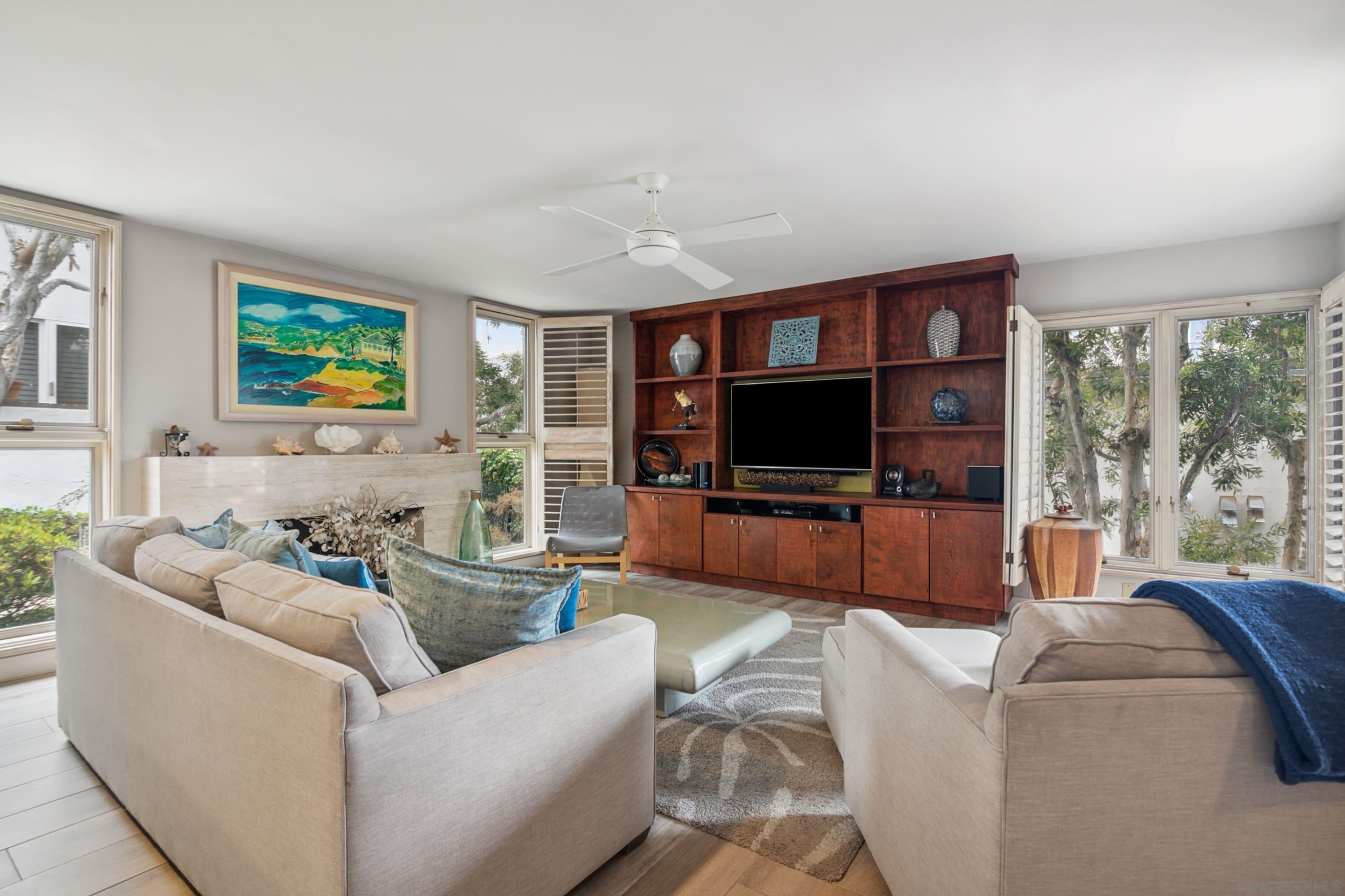 a living room with furniture a flat screen tv and a large window