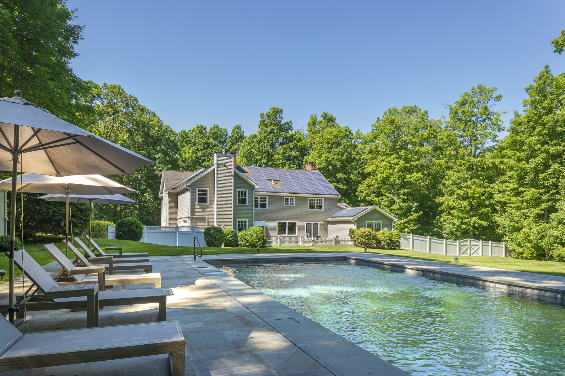 a view of house with garden space and swimming pool