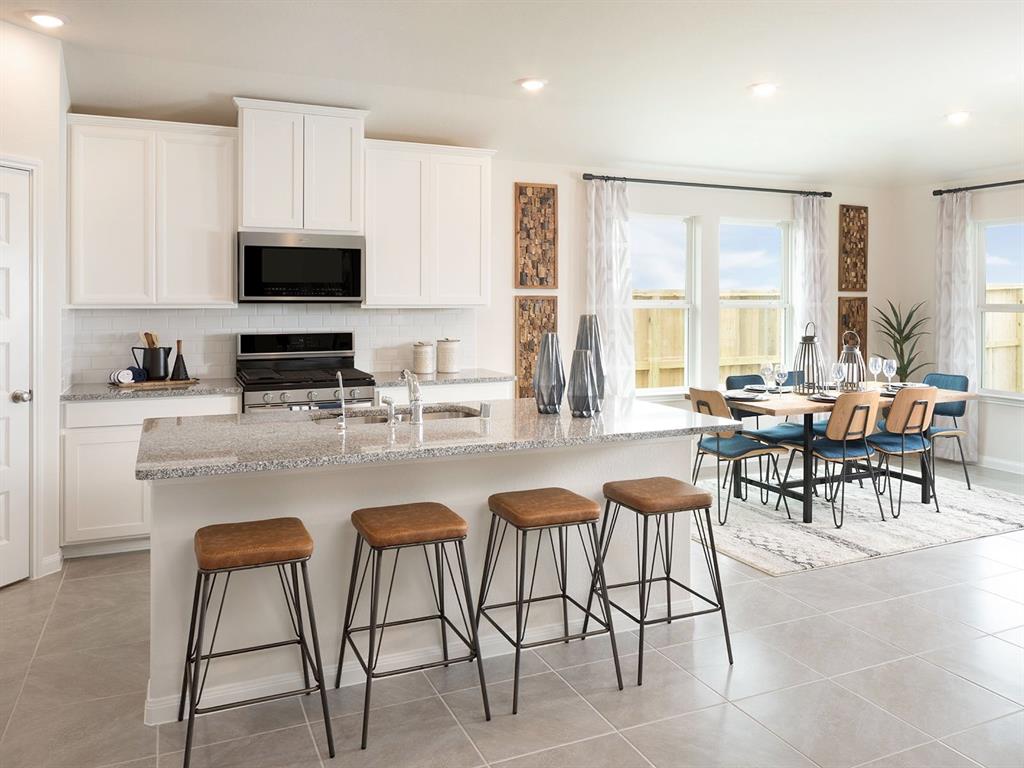 a kitchen with stainless steel appliances granite countertop a table and chairs in it