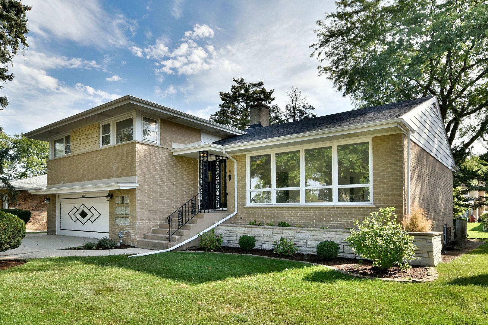 a front view of a house with a yard and outdoor seating