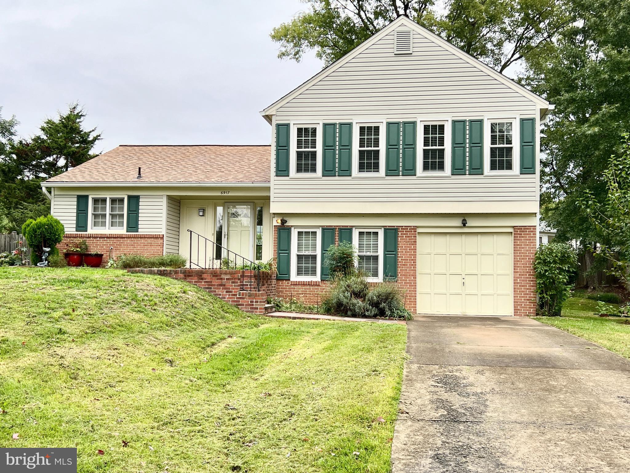 a front view of a house with a yard and potted plants