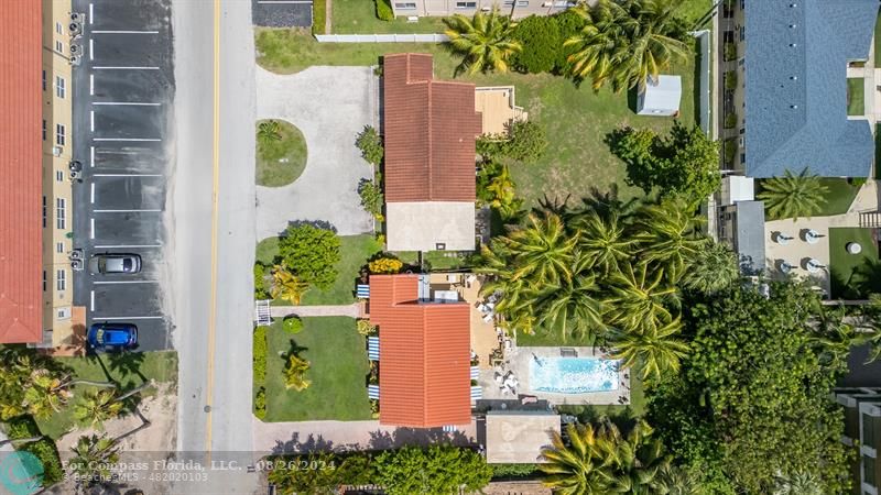 an aerial view of a residential apartment building with a yard and plants