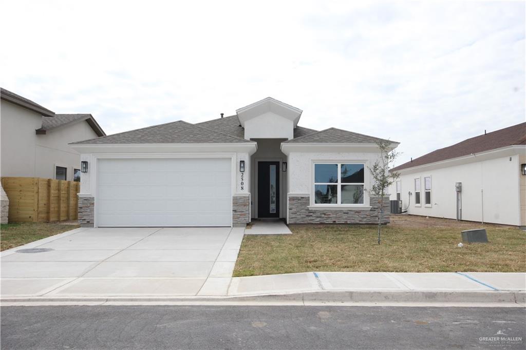 a front view of a house with a yard and garage